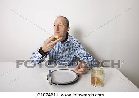 Senior man eating bread spread with sweet jelly jam at table View Large Photo Image Stock Image - Senior man eating bread spread with sweet jelly jam at table. Fotosearch