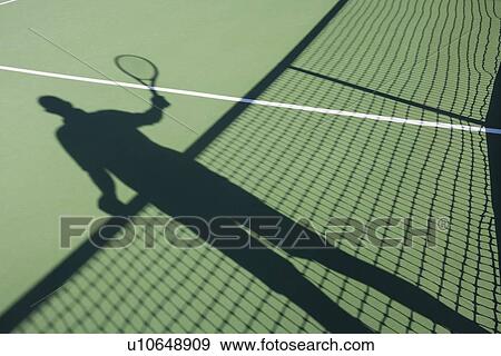 Stock Photo - Shadow of senior man playing tennis on court. Fotosearch