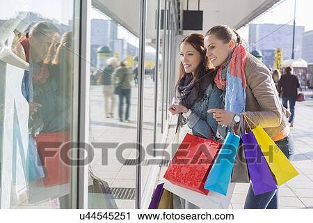 Shopaholic female friends window shopping View Large Photo Image Stock Image - Shopaholic female friends window shopping. Fotosearch