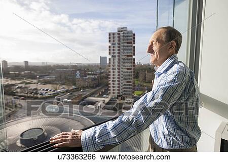 Side view of senior man standing on balcony View Large Photo Image Stock Photograph - Side view of senior man standing on balcony. Fotosearch
