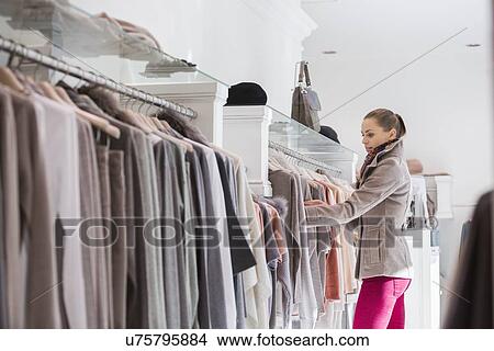 Side view of woman choosing sweater in store View Large Photo Image Picture - Side view of woman choosing sweater in store. Fotosearch