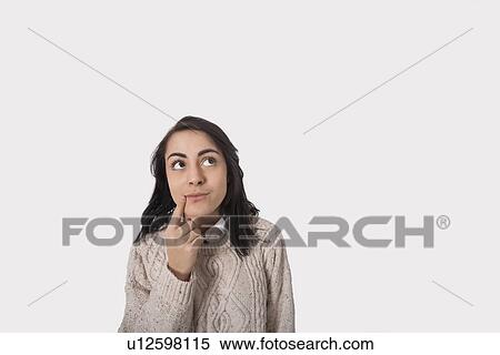 Thoughtful businesswoman against gray background View Large Photo Image Stock Photography - Thoughtful businesswoman against gray background. Fotosearch
