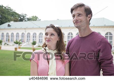 Thoughtful tourist couple smiling outdoors View Large Photo Image Stock Photograph - Thoughtful tourist couple smiling outdoors. Fotosearch