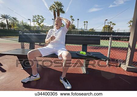 Tired senior tennis player relaxing on bench at court View Large Photo Image Stock Photography - Tired senior tennis player relaxing on bench at court. Fotosearch