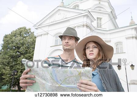 Tourist couple holding map outside St. Casimir Church, Warsaw, Poland View Large Photo Image Stock Photo - Tourist couple holding map outside St. Casimir Church, Warsaw, Poland. Fotosearch