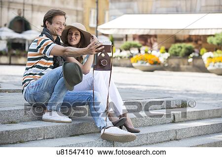 Stock Image - Tourist couple photographing on steps. Fotosearch
