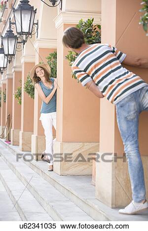 Stock Photography - Tourist couple playing hide-and-seek amongst columns. Fotosearch
