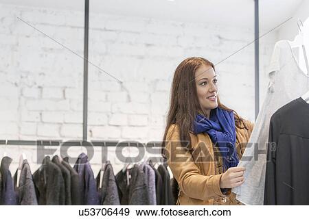 Woman analyzing top in store View Large Photo Image Stock Photo - Woman analyzing top in store. Fotosearch