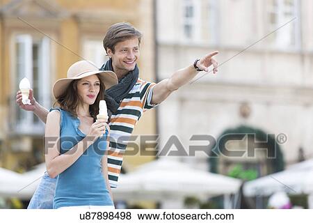 Young couple enjoying ice cream cones during vacation View Large Photo Image Stock Photo - Young couple enjoying ice cream cones during vacation. Fotosearch