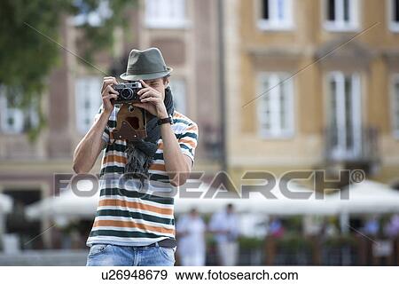 Young man photographing through vintage camera outdoors View Large Photo Image Stock Photo - Young man photographing through vintage camera outdoors. Fotosearch