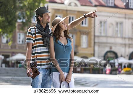 Young man showing something to woman during vacation View Large Photo Image Stock Photograph - Young man showing something to woman during vacation. Fotosearch