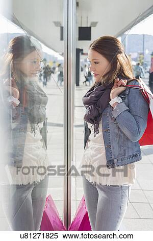 Stock Photography - Young woman in casuals window shopping. Fotosearch