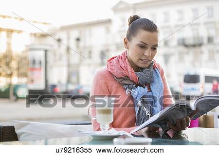 Young woman reading book at sidewalk cafe View Large Photo Image Stock Photography - Young woman reading book at sidewalk cafe. Fotosearch