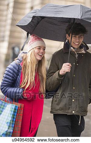 Stock Image - A young couple shop in the Grassmarket in Edinburgh, Scotland. Fotosearch