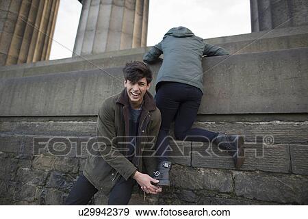 A young man helps his girlfriend climb onto the National Monument on Calton Hill in Edinburgh, Scotland View Large Photo Image Stock Photo - A young man helps his girlfriend climb onto the National Monument on Calton Hill in Edinburgh, Scotland. Fotosearch