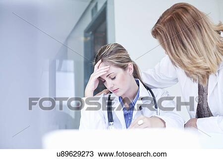 Anxious young female doctor and sympathetic colleague View Large Photo Image Stock Image - Anxious young female doctor and sympathetic colleague. Fotosearch