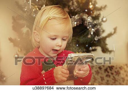 Picture - Baby girl with Christmas present. Fotosearch