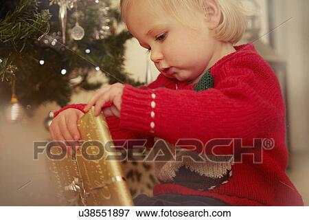 Stock Photo - Baby girl with Christmas present. Fotosearch