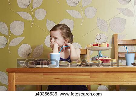 Bored looking girl at table with party food View Large Photo Image Stock Photograph - Bored looking girl at table with party food. Fotosearch