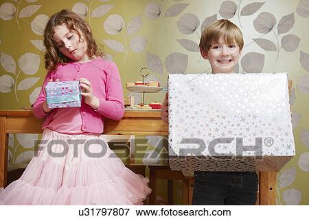 Boy and girl holding large and small present View Large Photo Image Stock Photo - Boy and girl holding large and small present. Fotosearch