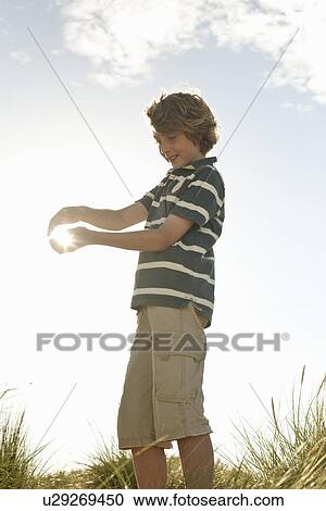 Boy capturing sun in his hands View Large Photo Image Stock Image - Boy capturing sun in his hands. Fotosearch