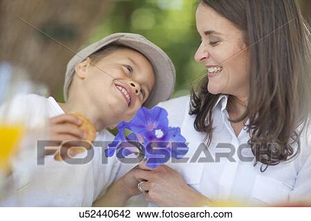 Stock Image - Boy giving flowers to mother. Fotosearch