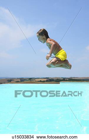 Boy jumping into swimming pool View Large Photo Image Picture - Boy jumping into swimming pool. Fotosearch