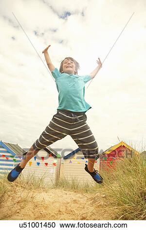 Boy jumping mid air at coast, Southwold, Suffolk, UK View Large Photo Image Stock Image - Boy jumping mid air at coast, Southwold, Suffolk, UK. Fotosearch