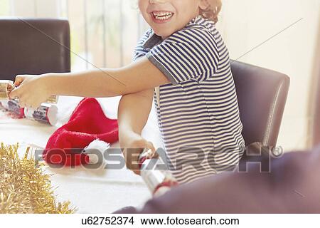 Picture - Boy pulling Christmas crackers. Fotosearch