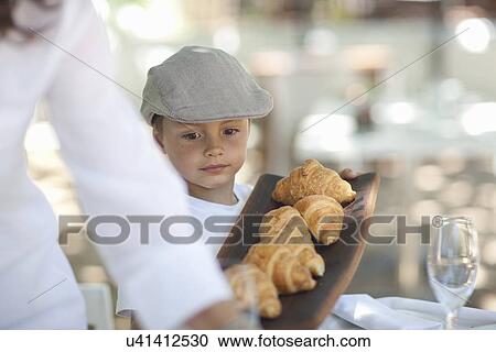 Boy serving platter of croissant View Large Photo Image Stock Image - Boy serving platter of croissant. Fotosearch