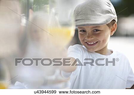 Stock Photo - Boy toasting with orange juice. Fotosearch