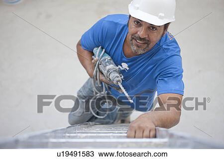 Builder with drill climbing ladder View Large Photo Image Stock Image - Builder with drill climbing ladder. Fotosearch
