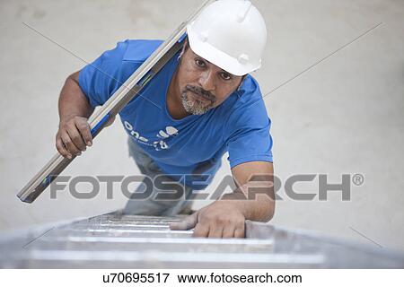 Builder with metal rod climbing ladder View Large Photo Image Stock Photo - Builder with metal rod climbing ladder. Fotosearch
