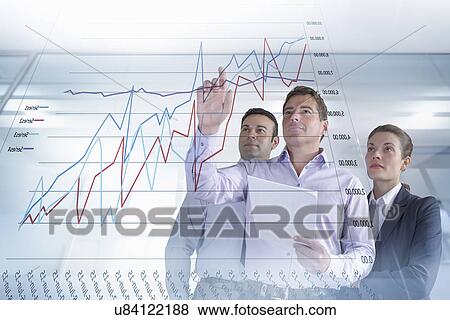 Stock Photo - Business colleagues discussing graphs and charts seen on interactive display. Fotosearch