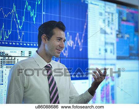 Stock Photograph - Businessman in front of presentation on graphical screens. Fotosearch