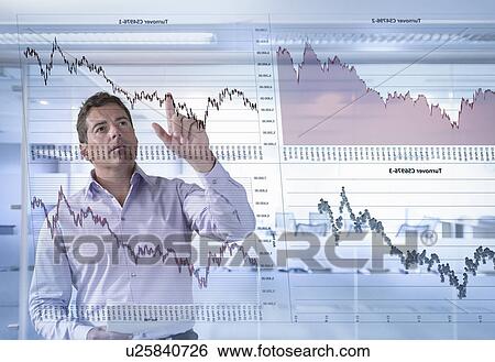 Stock Photograph - Businessman inspects graphs seen through interactive display. Fotosearch