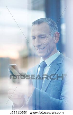 Businessman reading texts on smartphone View Large Photo Image Stock Image - Businessman reading texts on smartphone. Fotosearch