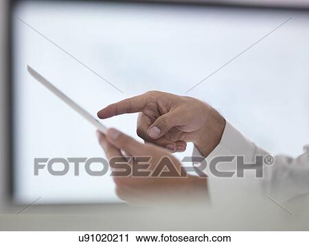 Stock Image - Businessman using digital tablet, close up. Fotosearch