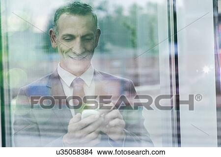 Businessman with glowing finger using smartphone touchscreen View Large Photo Image Picture - Businessman with glowing finger using smartphone touchscreen. Fotosearch
