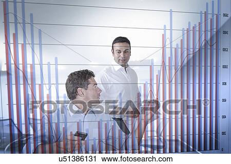 Stock Image - Businessmen discussing bar chart seen through screen. Fotosearch