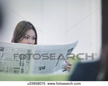 Stock Photography - Businesswoman reading Japanese newspaper. Fotosearch