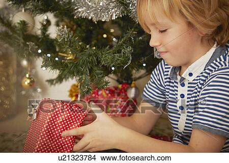 Picture - Child holding Christmas present. Fotosearch