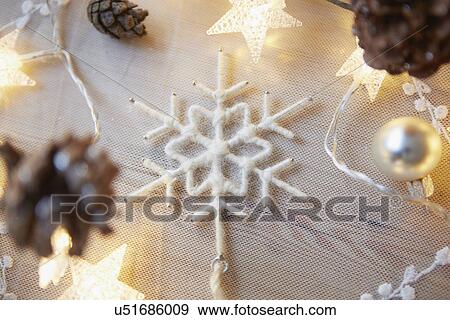 Stock Photo - Christmas table with decorative lights and fir cones. Fotosearch