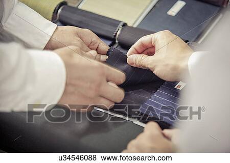 Close up of father and son choosing fabric in family tailors shop View Large Photo Image Stock Photo - Close up of father and son choosing fabric in family tailors shop. Fotosearch