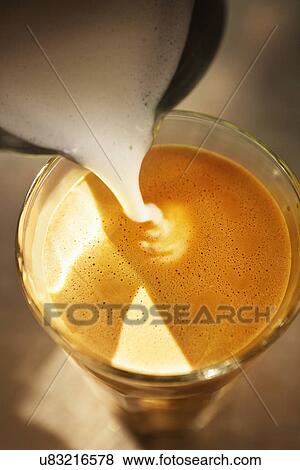 Close up of frothed milk pouring into coffee glass View Large Photo Image Stock Photo - Close up of frothed milk pouring into coffee glass. Fotosearch