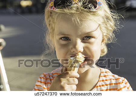 Stock Image - Close up of girl eating ice cream. Fotosearch