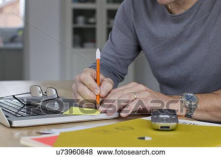 Close up of mature businessman working from home View Large Photo Image Stock Photo - Close up of mature businessman working from home. Fotosearch