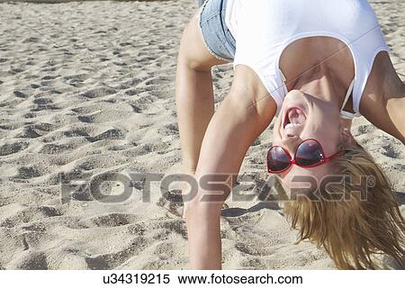 Close up of young woman bending over backwards on beach View Large Photo Image Stock Photography - Close up of young woman bending over backwards on beach. Fotosearch