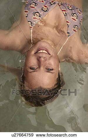 Close up of young woman floating in rock pool View Large Photo Image Stock Photo - Close up of young woman floating in rock pool. Fotosearch