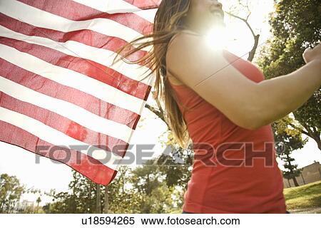 Close up of young woman running with american flag in park View Large Photo Image Stock Photography - Close up of young woman running with american flag in park. Fotosearch